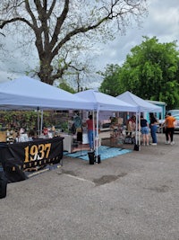 a street market with tents and tables in a parking lot