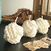 three white candles are sitting on a table